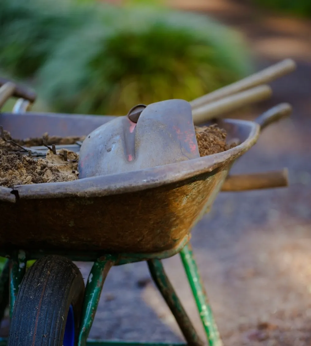 Schubkarre mit Erde und Gartenwerkzeug
