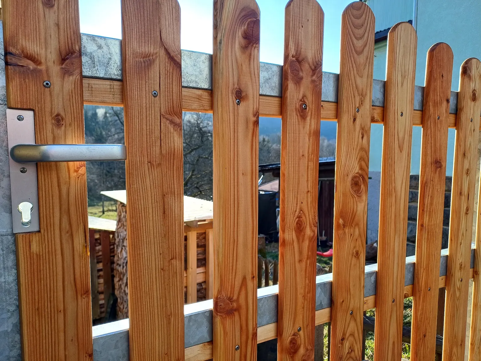Detail des selbst gebauten Holztors mit Metallbeschlag