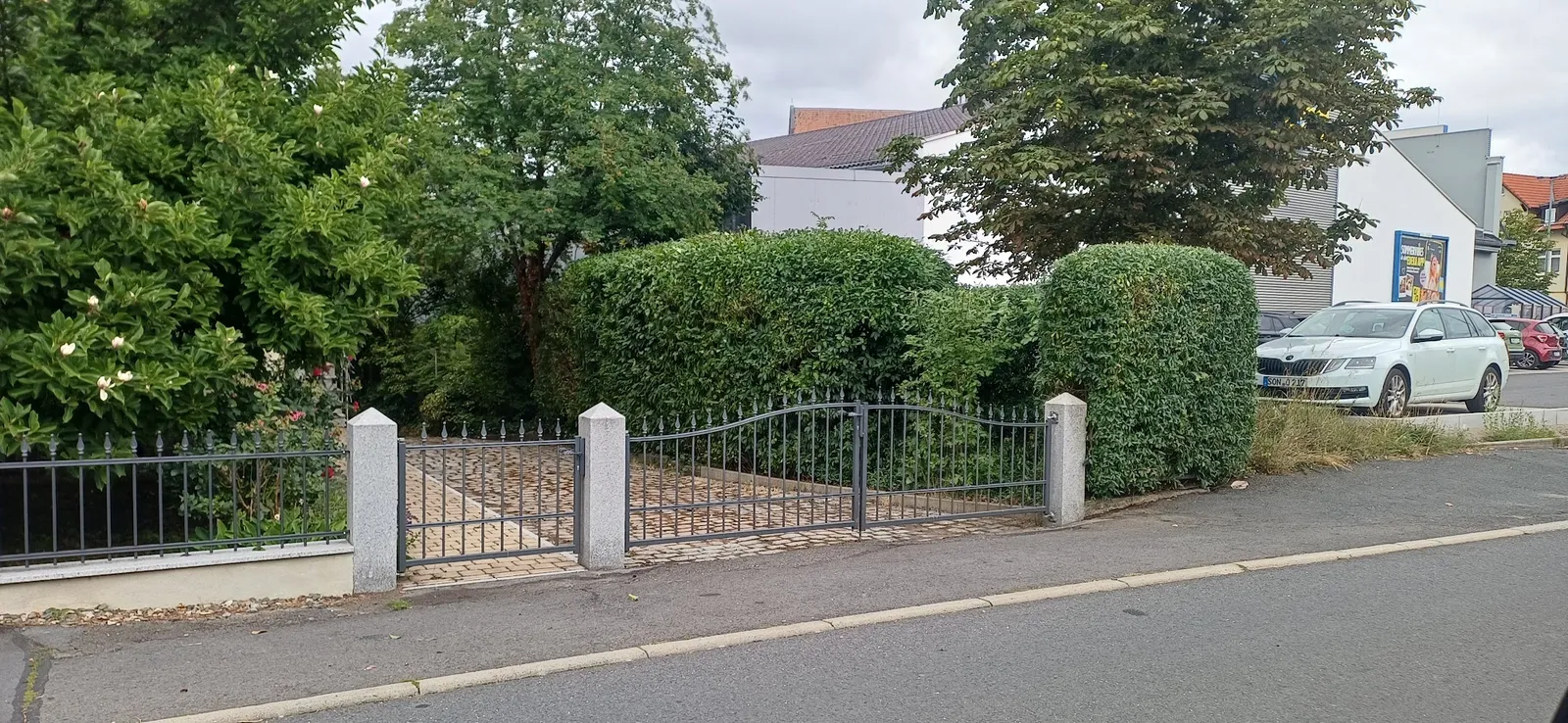 Gepflegte Hecke neben einem Metalltor
