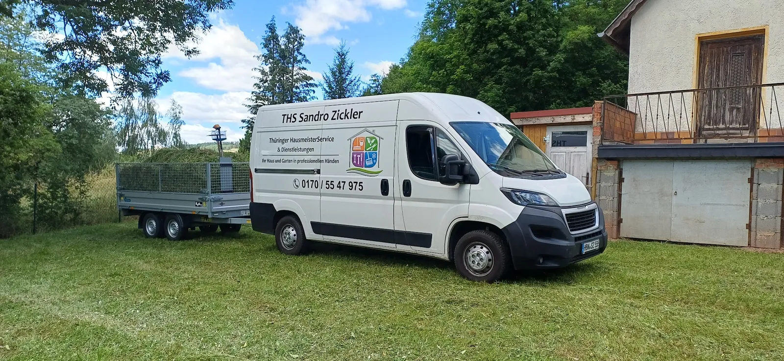Firmentransporter mit beladenem Anhänger nach der Gartenreinigung